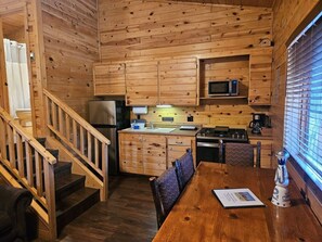 There is a 4-person dining table by the front window.