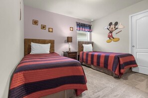 Charming twin bedroom with a playful Mickey Mouse theme, perfect for kids to enjoy a magical stay.