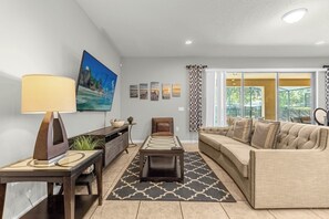 Relax in this stylish living room with a cozy sofa, modern decor, and easy access to the patio for a perfect blend of indoor and outdoor living.