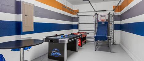Unleash your competitive spirit in this vibrant game room with air hockey, foosball, and basketball games!