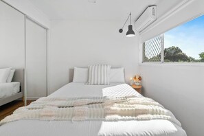 The second bedroom has a comfortable queen bed with soft throw pillows and a throw blanket to stay cosy. Enjoy the convenience of air-conditioning, large wardrobe storage and room-darkening blinds. 
