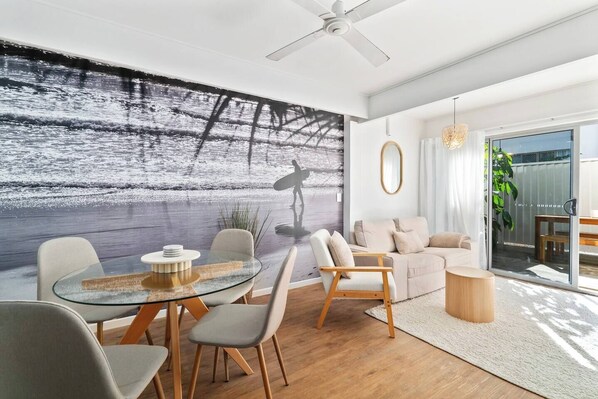 Enjoy meals together in the open-plan dining area where a classic round glass table comfortably seats four guests. 
