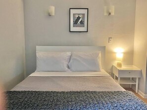 Eco-Latex mattress, high-end bedding, roomy bedroom with chair and dresser and full closet.