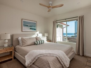 The second bedroom featuring an ocean view and a plush king-sized bed