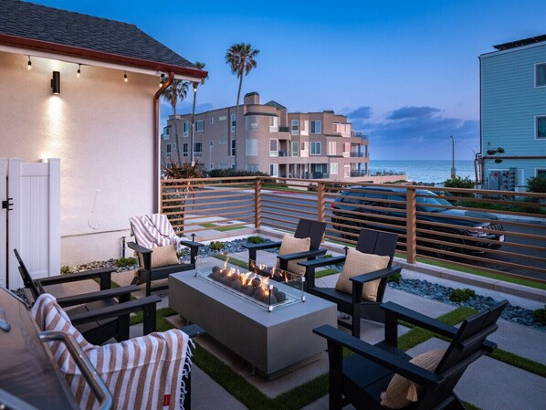 Relax by the firepit on the patio with stunning ocean views.