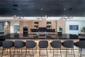 The spacious kitchen island offers additional seating for 14 guests.