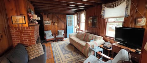 Cozy wood-paneled living room with two pull out sofa beds