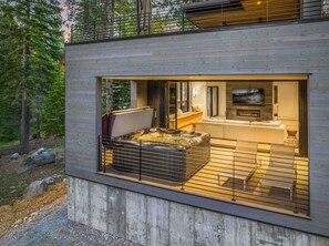 Exterior: Lower level deck, 8-person hot tub, Bose outdoor speakers, outdoor chaise lounge chairs, forested and creek views