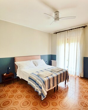 BLUE bedroom - divisible double bed, bedside tables, wardrobe, armchair and ceiling fan.