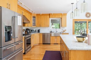 A spacious kitchen with stainless steel appliances awaits your culinary creativity. 