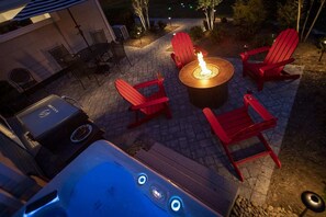 Back patio with hot tub and fire pit at night. Cook your breakfast or dinner on the Blackstone grill. 

The hot tub will be treated daily during your stay to ensure the chemicals stay balanced and water clear.