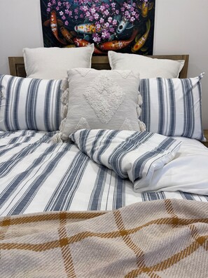 Luxurious bedding: soft quilt, fluffy pillows for ultimate comfort.