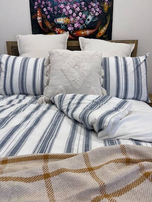 Luxurious bedding: soft quilt, fluffy pillows for ultimate comfort.