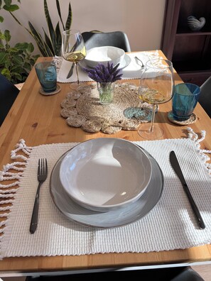 Enjoy dining at a beautifully set table complete with fancy wine glasses.