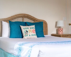 The tranquil queen suite offers an attached bath, TV, & balcony access