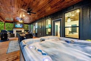 The outdoor patio features a hot tub, dining area, and living areas
