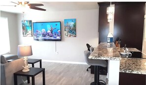 Left Side = Living room + TV, Right Side is Kitchen countertop dining area.