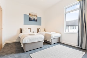 Bedroom 1: two single beds with fresh linen and towels provided.