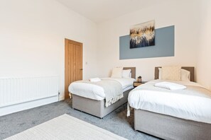 Bedroom 1: two single beds with fresh linen and towels provided.