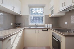 The kitchen comes well equipped to prepare meals at home, with an oven, stove, and microwave.