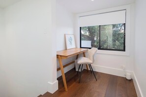 A timeless wooden writing desk provides an ideal spot for remote workers or creatives looking for a quiet and productive nook. 
