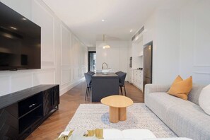 The dining area flows from the open-plan kitchen and features a slick black table with six modern curved wing dining chairs. 
