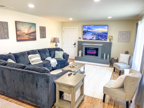 Comfortable living room with giant tv and sectional couch.