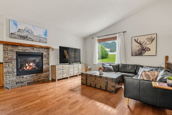 Main floor living room with a gas fireplace and a 65" Smart TV