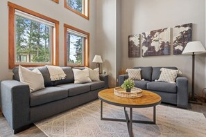 Living room with a gas fireplace, pull-out couch bed & dedicated workstation.