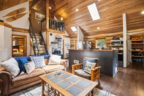 Huge open concept living room and kitchen with vaulted ceilings and skylights make for a large gathering space.