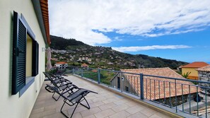 Relax on the patio of Capelas House by Lovelystay: Sunloungers with mountain and partial ocean views, perfect for a serene escape. #serenity #madeiraexperience