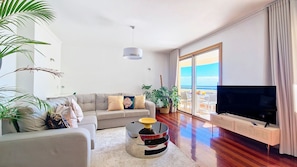 Unwind in the spacious living room of Glorious Apartment, featuring a large smart TV and panoramic ocean views. Experience comfort and luxury in this captivating seaside retreat. #freewifi #oceanview