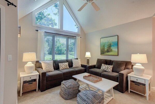 The open living space boasts vaulted ceilings and stunning views of the golf course from the living room.