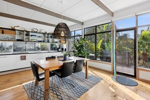 Large windows connect the interior with the expansive outdoor deck, enhancing the home’s open and airy feel