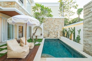 Relax on the beanbag under the standing umbrellas after swimming in the pool.