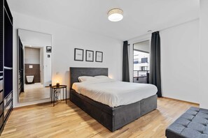 Spacious bedroom with a comfortable queen-sized bed and direct access to a modern, sleek bathroom.