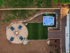 Aerial view of your private backyard oasis. Featuring a cozy firepit, relaxing hot tub, and AstroTurf area perfect for pups to play and roam.
