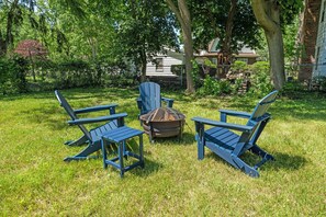 Patio in the backyard with adirondack chairs and fire pit