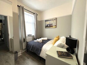 Bedroom 1 - Cosy room with small double bed, wardrobe, blackout curtains and bedside table