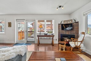 Living room with pull-out couch, electric fireplace & Smart TV with access to the private balcony