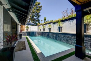 A recently installed pool with baja shelf and raised spa that are completely private. The pool is solar heated