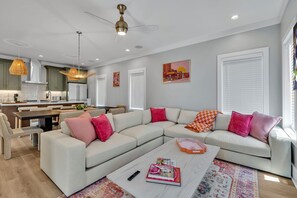 2nd Floor: Warm and inviting open-concept living space seamlessly flowing the designer furnished living room with the fully equipped kitchen and dining area.