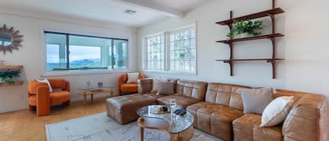 The living room is roomy and filled with natural light