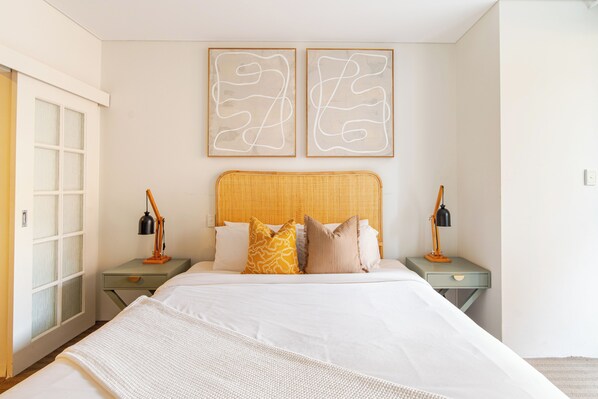 Unwind in this inviting bedroom, featuring a comfortable bed, stylish decor, and a touch of natural light.