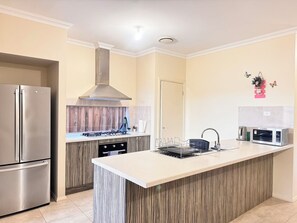 The fantastic kitchen is fully equipped with essential appliances.