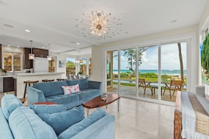 Enjoy the open living area with comfortable seating and large windows showcasing the stunning ocean view.