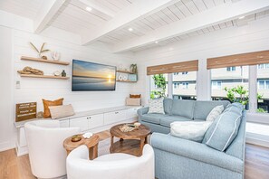 Relax in the comfortable living room with brand new furniture & coastal decor.