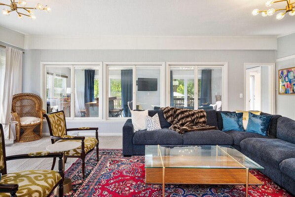 Family Room, opening up to the Bar/Game Room, with plenty of seating and a 75-inch Samsung Smart TV