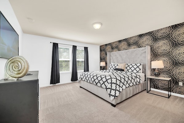 Retreat to this stylish and spacious king suite featuring a luxurious bed, modern decor, and a chic accent wall.