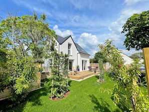La maison depuis le jardin avec aménagement paysage.